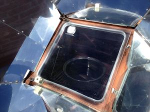 After sieving out the simmered fruit, the liquid is being concentrated in a solar oven with oven cover slightly open to release moisture (MABurgess photo)